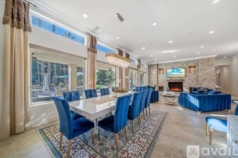 A dining room with a long table and blue chairs.