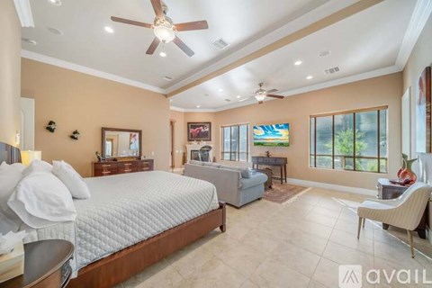 A bedroom with a large bed and a ceiling fan.
