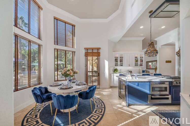 A modern kitchen with blue chairs and a dining table.