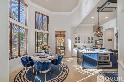 A modern kitchen with blue chairs and a dining table.