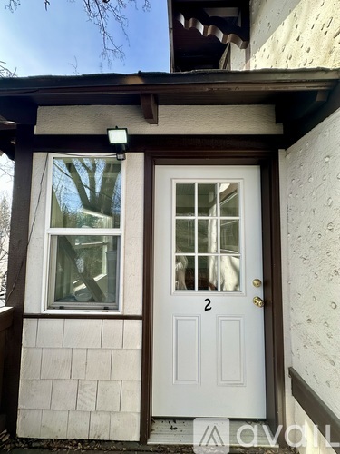 A white door with a glass window above it and a number 2 on it.