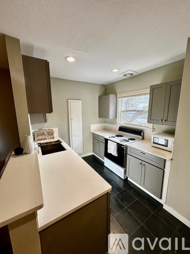 A kitchen with white countertops and a window.