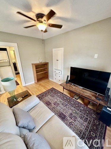 A living room with a television and a ceiling fan.