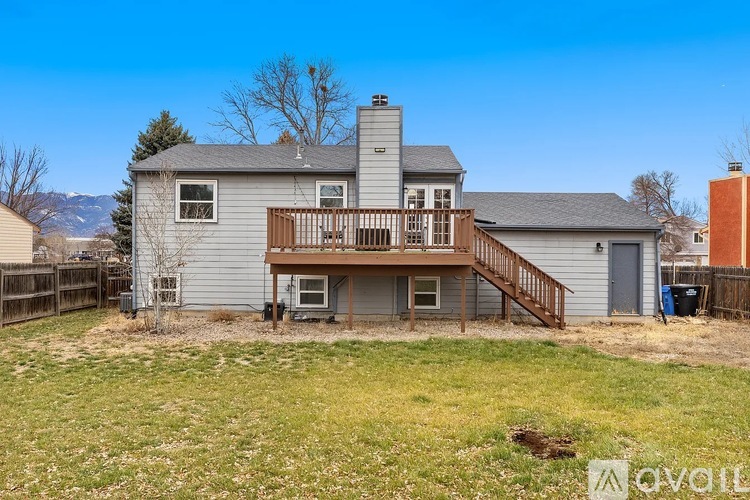 A house with a grey exterior and a wooden deck.