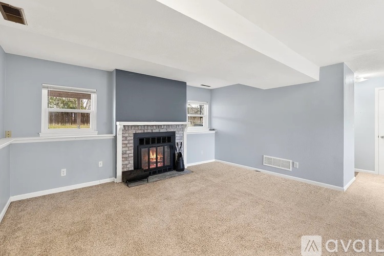 A living room with a fireplace and a window.