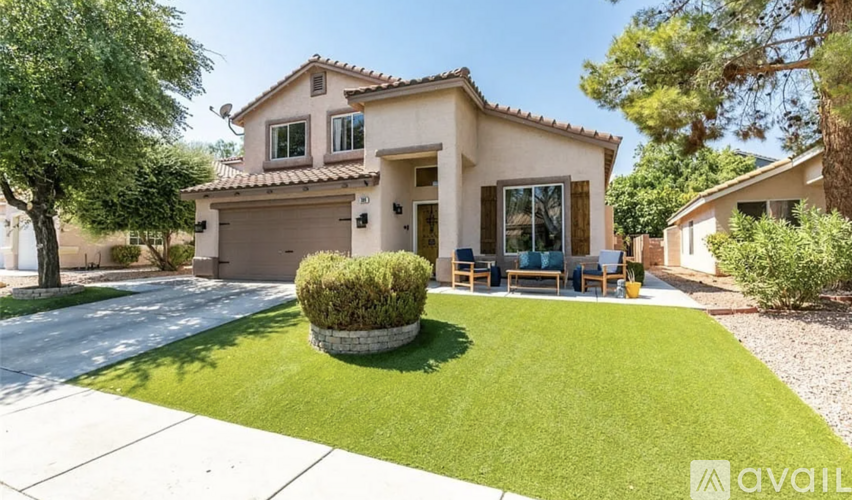 A house with a well-maintained lawn and a tree in front of it.
