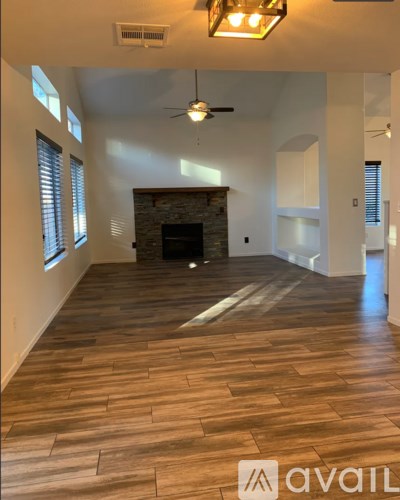 A spacious living room with a fireplace and wood flooring.