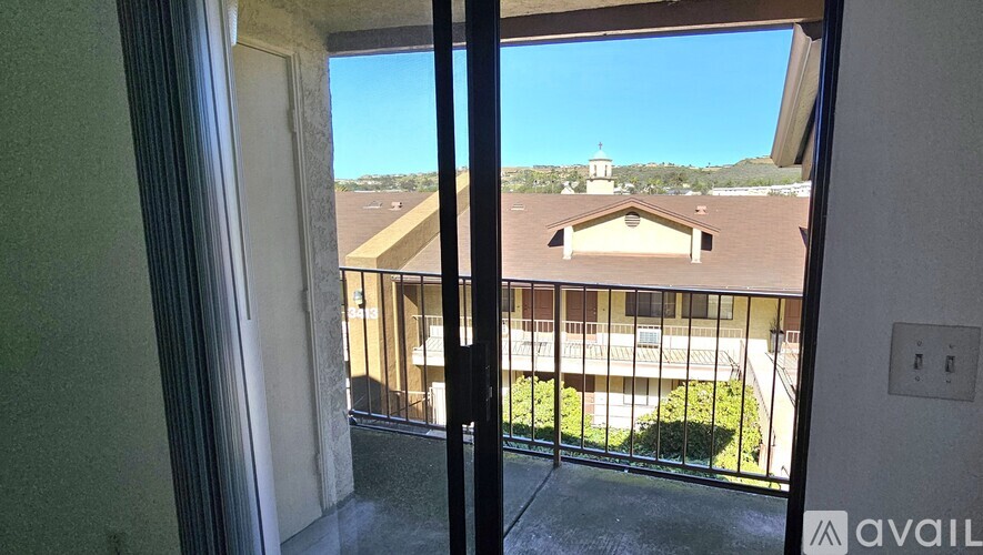 A balcony with a view of a building and trees.