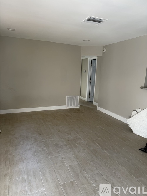 A room with light grey walls and a wooden floor.
