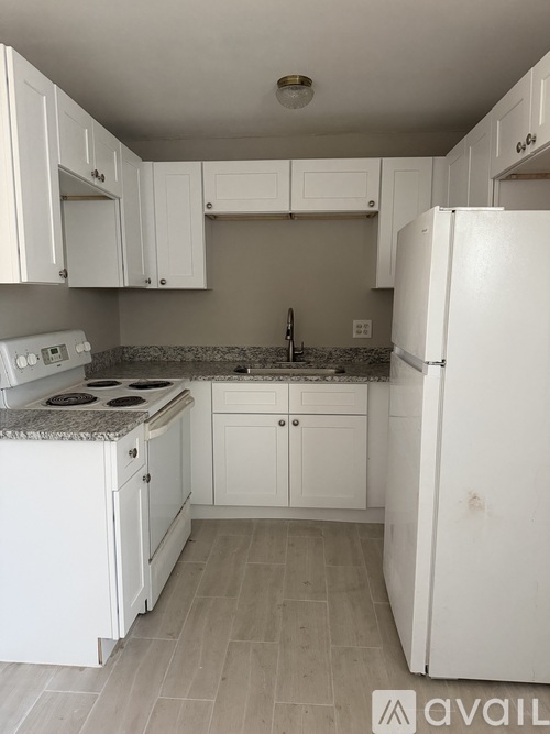 A kitchen with white appliances and cabinets.