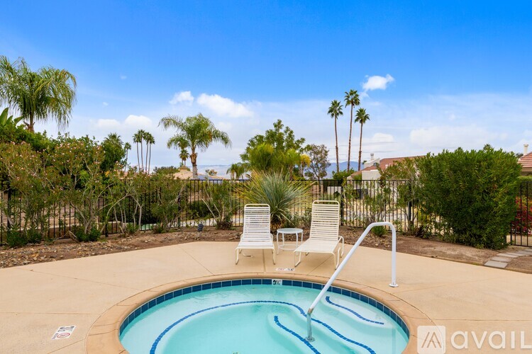 A pool with a chair and a fence in the background.