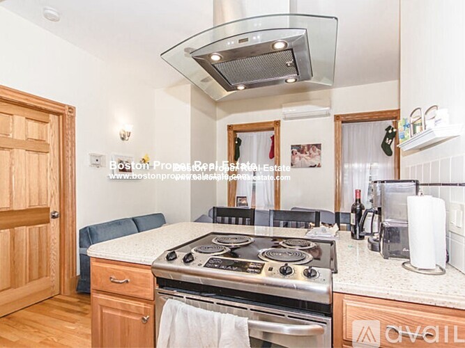 A kitchen with a stove top oven and a hood above it.