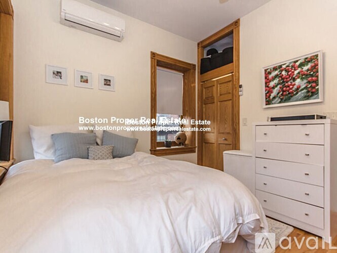 A bedroom with a large bed and a painting on the wall.