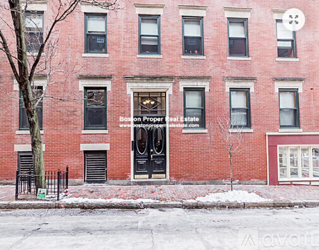 A red brick building with a black door and windows.
