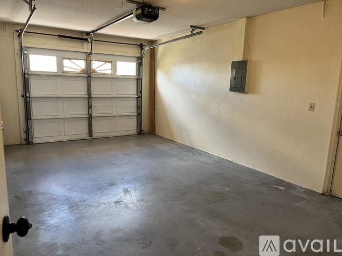 A spacious garage with a closed white door and a concrete floor.