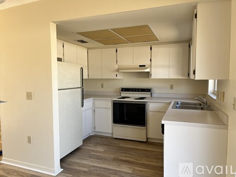 A kitchen with white appliances and cabinets.