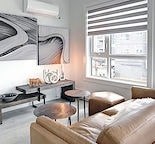 A living room with a couch, a table, and a large picture on the wall.