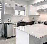 A modern kitchen with a white counter top.