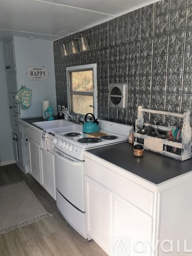A kitchen with white cabinets and a black countertop.