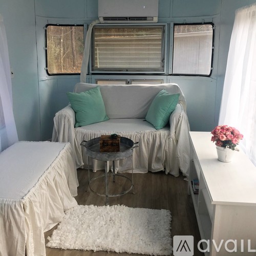 A living room with a white couch and a glass coffee table.