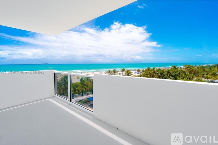 A balcony with a view of the ocean and trees.