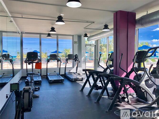 A gym with treadmills, exercise bikes, and elliptical machines.