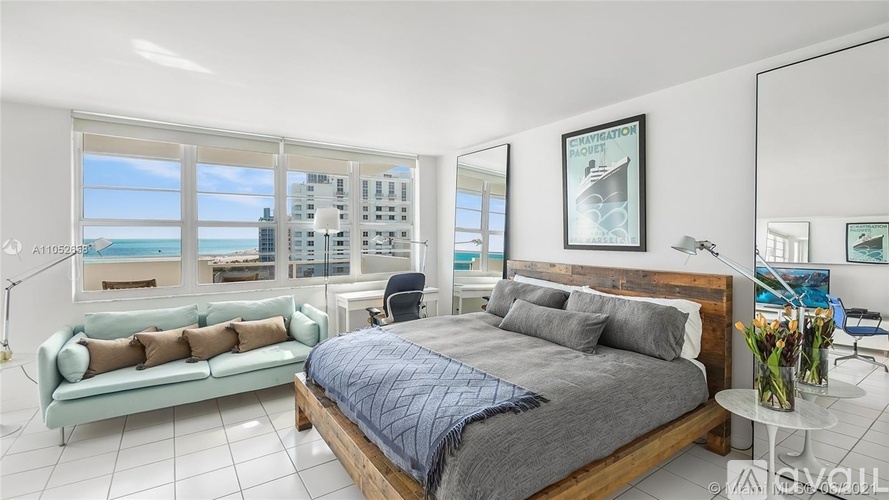 A bedroom with a large bed and a view of the city.