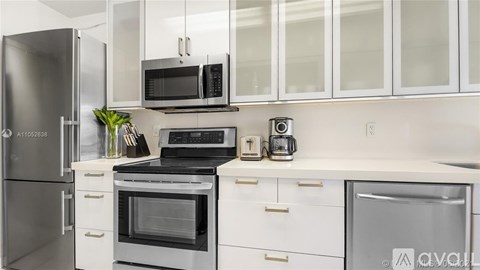 A kitchen with white cabinets and stainless steel appliances.