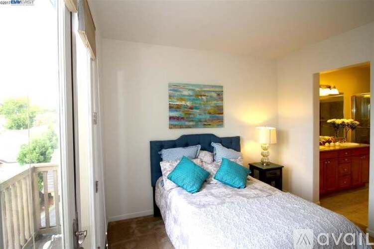 A bedroom with a large bed and a painting on the wall.