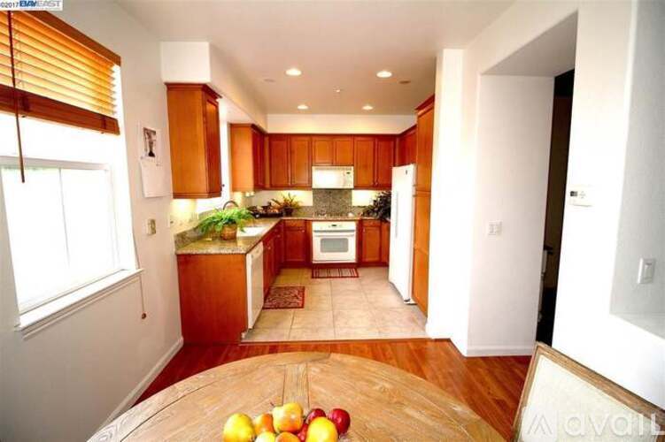 A kitchen with wooden cabinets and a refrigerator.