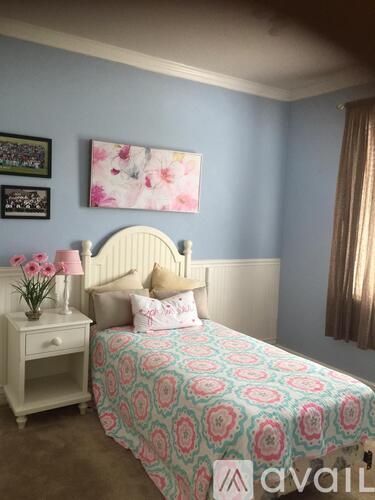 A bedroom with a bed, nightstand, and wall art.