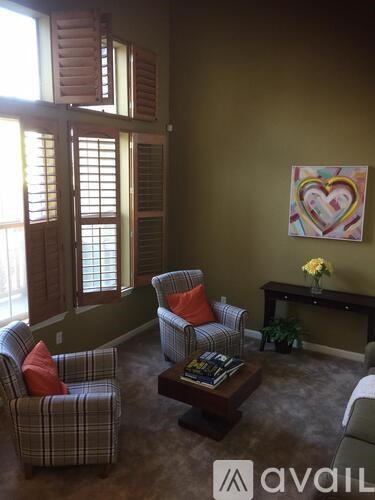 A living room with a heart-shaped painting on the wall.