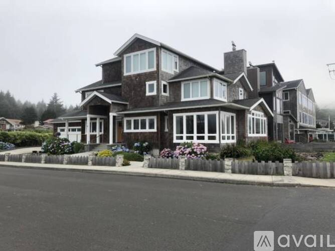 A large house with a grey roof and white windows is available for sale.