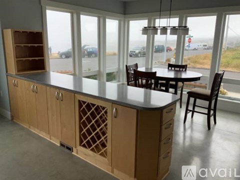 A kitchen with a table and chairs in front of a window.