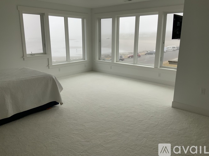 A bedroom with a large bed and a view of the beach.