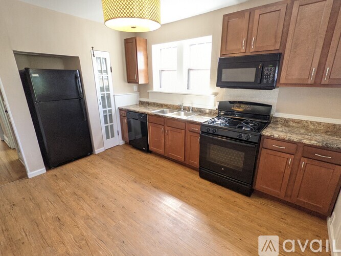 A kitchen with wooden cabinets and black appliances.