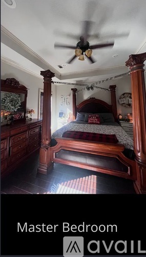 A bedroom with a bed, dresser and a ceiling fan.