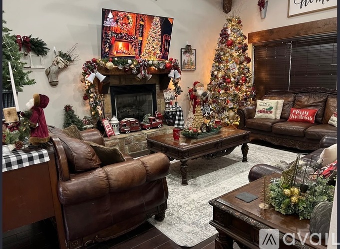 A living room decorated for Christmas with a fireplace, a Christmas tree, and a TV screen showing a Christmas scene.