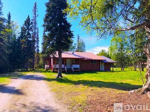 A house with a red roof is surrounded by trees.