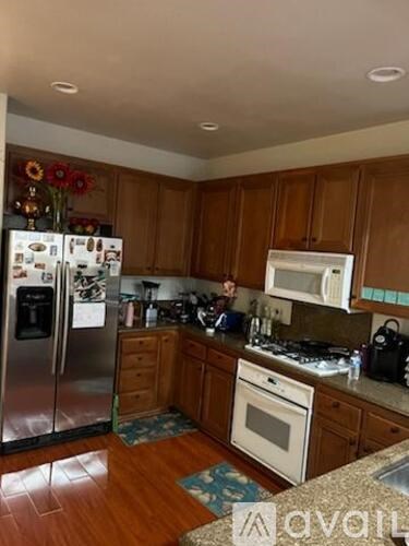 A kitchen with wooden cabinets and a stainless steel refrigerator.