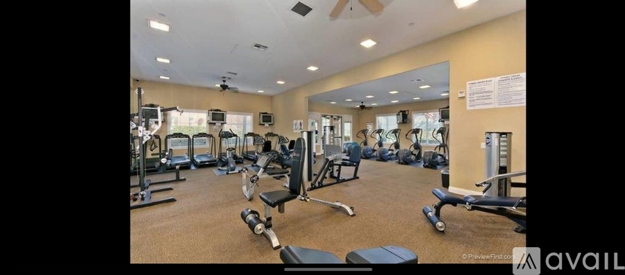 A gym with a variety of equipment including treadmills, weights, and exercise machines.