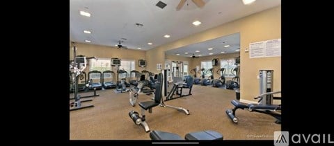 A gym with a variety of equipment including treadmills, weights, and exercise machines.
