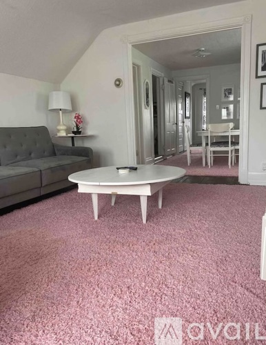 A living room with a grey couch and a white coffee table.
