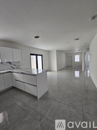 A spacious, empty room with a marble countertop and tiled floor.
