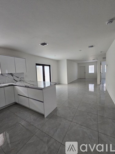 A spacious, empty room with a marble countertop and tiled floor.