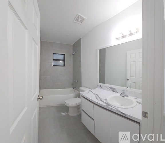A bathroom with a toilet, sink, and bathtub.