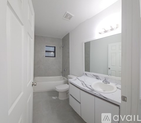 A bathroom with a toilet, sink, and bathtub.