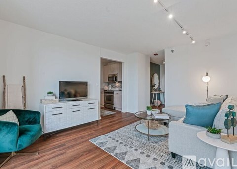 A living room with a white couch, a blue chair, and a wooden floor.