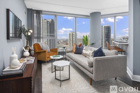 A living room with a grey couch, a brown armchair, and a white coffee table.