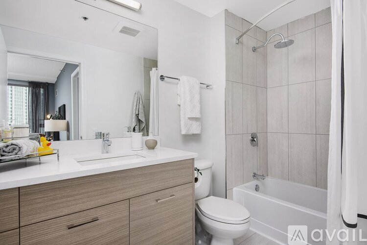 A modern bathroom with a white sink, toilet, and bathtub.